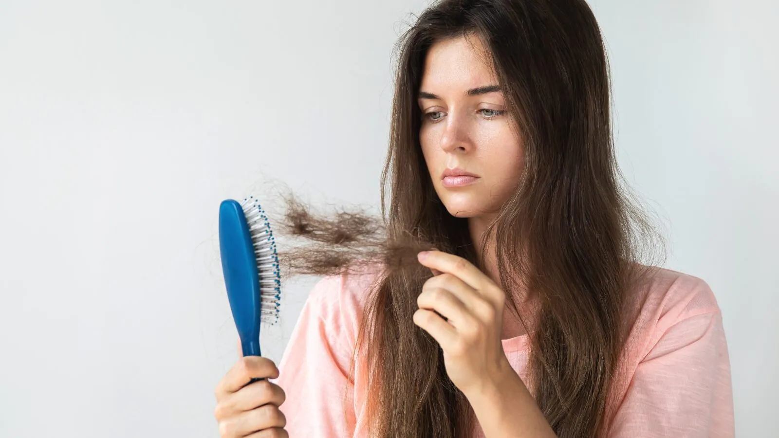 A girl taking out hairs from hair brush