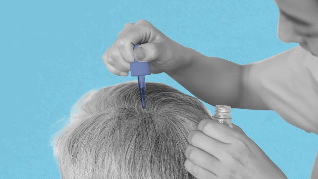A men dropping a hair oil on an other mens head
